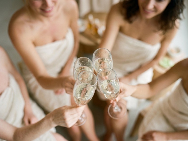 Brindisi tra amiche avvolte negli accappatoi durante una giornata di benessere